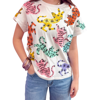 Woman wearing short sleeve Queen of Sparkles Crawling Rainbow Tiger Tee with scattered sequin multi color tigers on a white tshirt