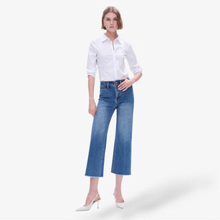 Woman wearing a white shirt and blue jeans on a white background