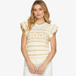 A woman wearing a beige and white striped crochet top with flutter sleeves and daisy crochet detail across the chest.