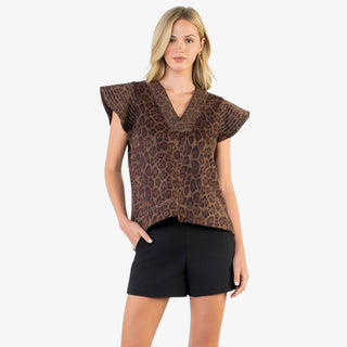 Woman wearing leopard print V-neck flutter sleeve top with relaxed fit