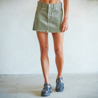 Woman wearing olive green denim mini skirt with raw hem