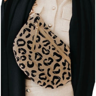 Woman wearing a Pretty Simple Jolie Puffer Belt Bag in leopard quilted nylon with gold zipper, styled with a white top and denim jeans.