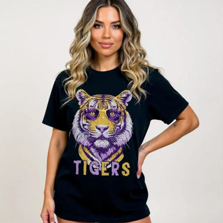 Woman wearing a black t-shirt with a tiger graphic and 'TIGERS' text on a plain background