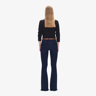 Woman wearing Mid Rise Flare Jeans in deep-water indigo denim with brown belt and black top, styled with heeled boots.