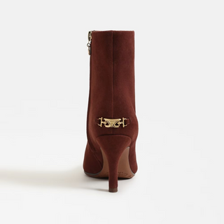 Brown ankle boot with gold decorative buckle on a white background