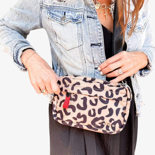 Lady wearing denim jacket and black skirt, carrying a leopard crossbody on a white background