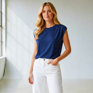 Women's blue cap sleeve top styled with white pants for boutique fashion.