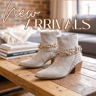 New Arrivals banner featuring neutral suede ankle boots with gold chain detail on coffee table, representing wome's clothing, shoes, jewelry and accessories.