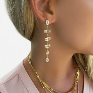 Bold gold chain link drop earring with oversized oval links worn on a model’s ear in a close-up view.