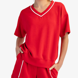 Shop red scuba V-neck top with contrast piping—sporty, flattering athleisure style perfect for everyday wear or matching sets.