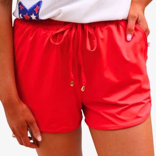 Red drawstring shorts with elastic waistband and pockets styled with patriotic star top front view