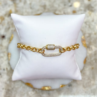 Gold Bracelet with diamond lock on a white pillow and beige background