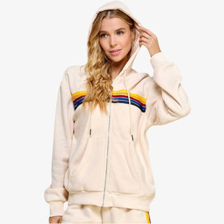 Woman wearing striped zip hoodie with rainbow stripe design in cream fleece