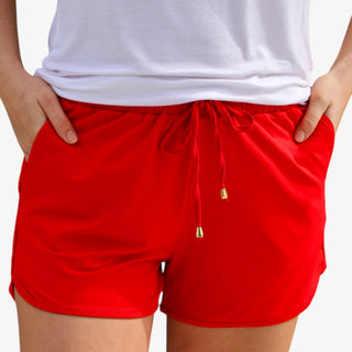 Red drawstring shorts with elastic waistband and pockets styled with patriotic star top front view