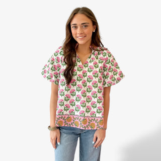 Pink floral split neck top with short sleeves and green leaf print front view.