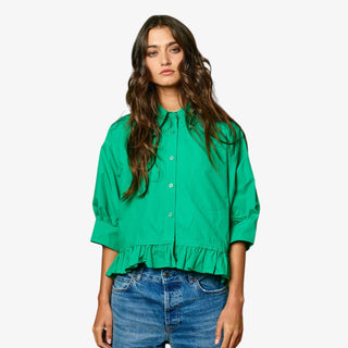 Woman wearing a green shirt and blue jeans on a white background
