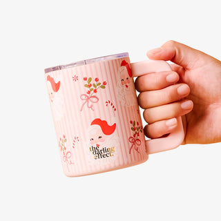 Hand holding a pink mug with decorative designs and 'the darling effect' branding on a white background