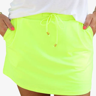 Neon yellow athletic skort with drawstring waist and built-in shorts styled with pineapple graphic top front view