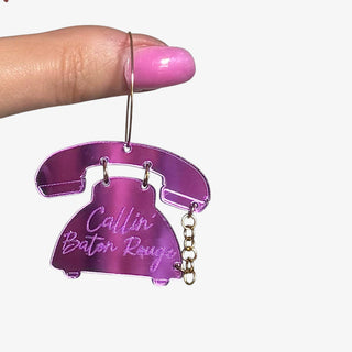 Purple Calling Baton Rouge hoop earrings featuring acrylic rotary phone charms with gold hoops displayed on a hand for size reference.