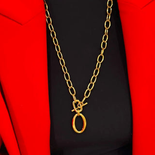 Gold chain necklace with a clasp on a black background