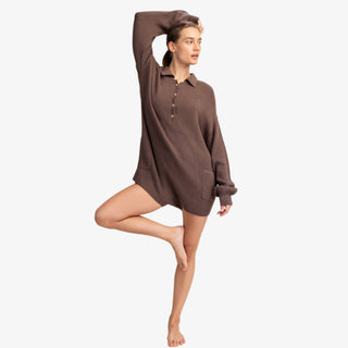 Woman wearing ribbed knit sweater romper with collared neckline and button front