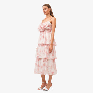 Pink floral tiered midi dress with bow detail bodice and ruffle layers styled with white heels