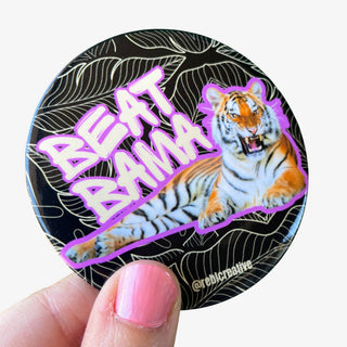 3-inch Beat Bama game day button featuring a roaring tiger with purple lettering on a black leaf-patterned background, front view
