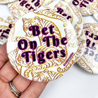 3-inch Bet on the Tigers game day button with purple lettering and gold tiger illustrations on a white background, front view
