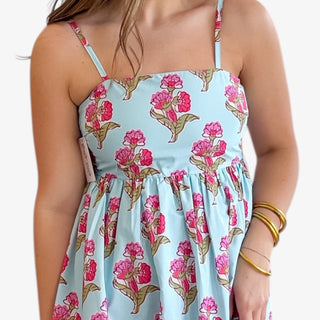 Close-up of blue floral maxi dress with pink floral print, square neckline, adjustable straps, and gathered waist detail showing fabric and fit