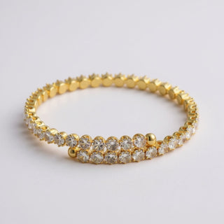 Gold bracelet with clear cz stones on a light gray background