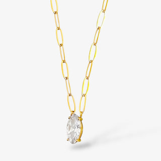 Gold chain necklace with a clear crystal pendant on a light gray background
