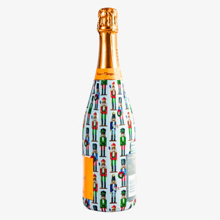 Champagne bottle wrapped in WH Hostess Nutcracker design with colorful holiday characters, fits most 750ml bottles for gifting or entertaining.
