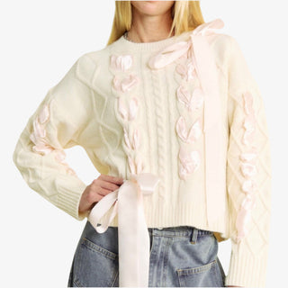 Ivory woven bow sweater with satin ribbon details and cable knit design