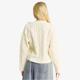 Ivory woven bow sweater with satin ribbon details and cable knit design