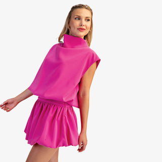 Mock neck balloon top in hot pink with draped silhouette and cap sleeves
