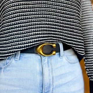 Classic belt featuring a bold gold C-shaped buckle, shown in black, brown, and white color options styled with light wash jeans for a chic, everyday polished look.