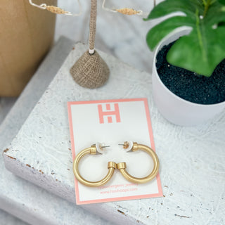 Hoo Hoops brushed gold earrings small chunky matte hoop earrings on pink jewelry card with tropical styled background