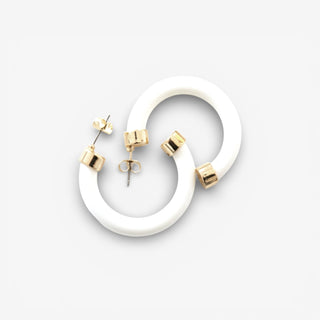 Small crisp white hoops with gold accents on a grey background 