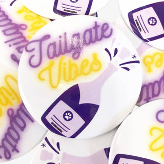 Tailgate Vibes button in purple and gold with champagne bottle graphic, perfect for game day spirit accessory