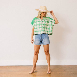 Sunshine Tienda green tropical print top with denim shorts and straw hat styled for vacation outfit full body view