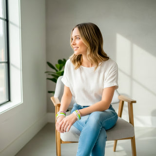 Woman wearing pastel BuDhaGirl Three Kings Blossom II bangles with white tee and denim jeans in bright studio lifestyle view