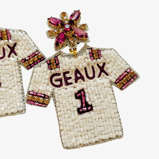 Decorative brooch shaped like a beaded shirt with 'GEAUX' and number '1' on a white background