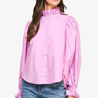 Pink blouse with long sleeves and a high collar worn by a person on a white background