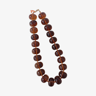 A beaded necklace made of polished dark brown translucent gemstone beads strung on a matching brown cord, with a small gold clasp, shown against a light gray background.