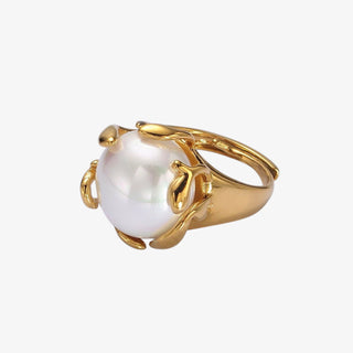 Gold signet ring with sculptural claw design holding round white shell pearl