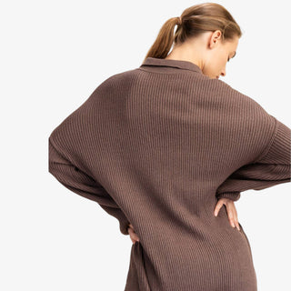 Woman wearing ribbed knit sweater romper with collared neckline and button front