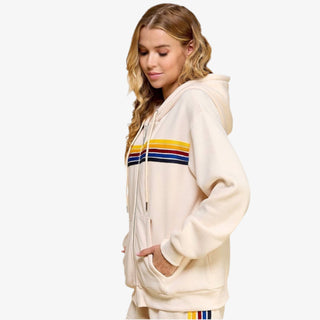 Woman wearing striped zip hoodie with rainbow stripe design in cream fleece