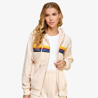 Woman wearing striped zip hoodie with rainbow stripe design in cream fleece