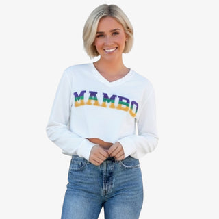 Woman wearing a white sweatshirt with 'MAMBO' in colorful letters on a white background