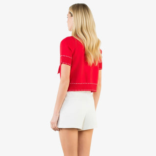 Contrast stitch knit button up top with short sleeves, decorative buttons, and tailored pockets in red or white